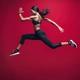 atletisk tjej gör jättehopp med röd bakgrund.jpg (1)