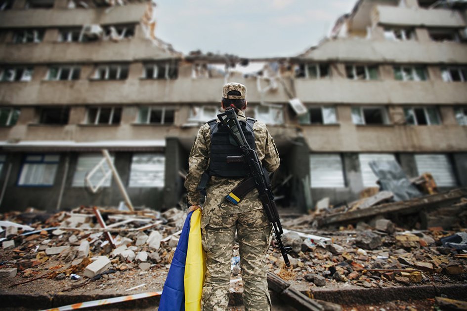 Soldat Med Ukrainsk Flagga Framför Skadad Byggnad
